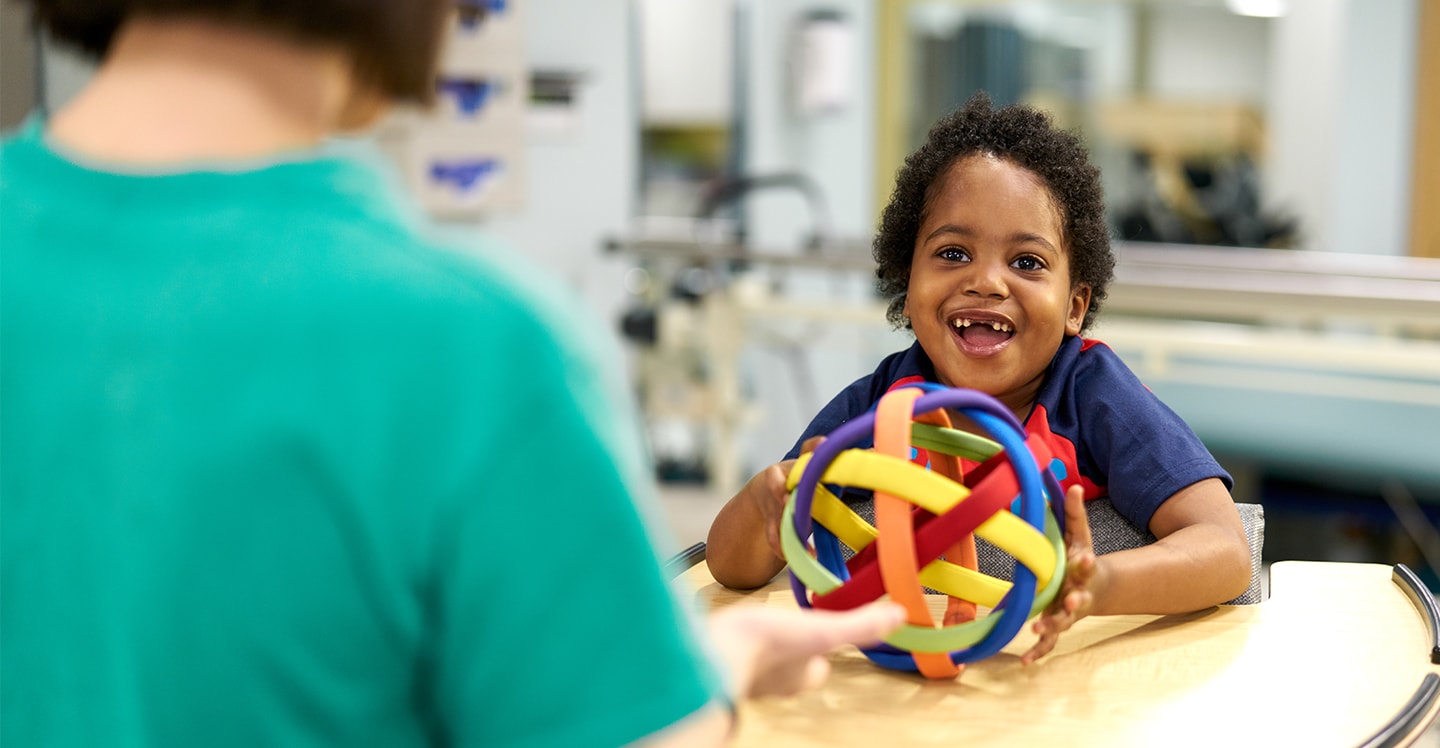 Young patient participates in occupational therapy with therapist