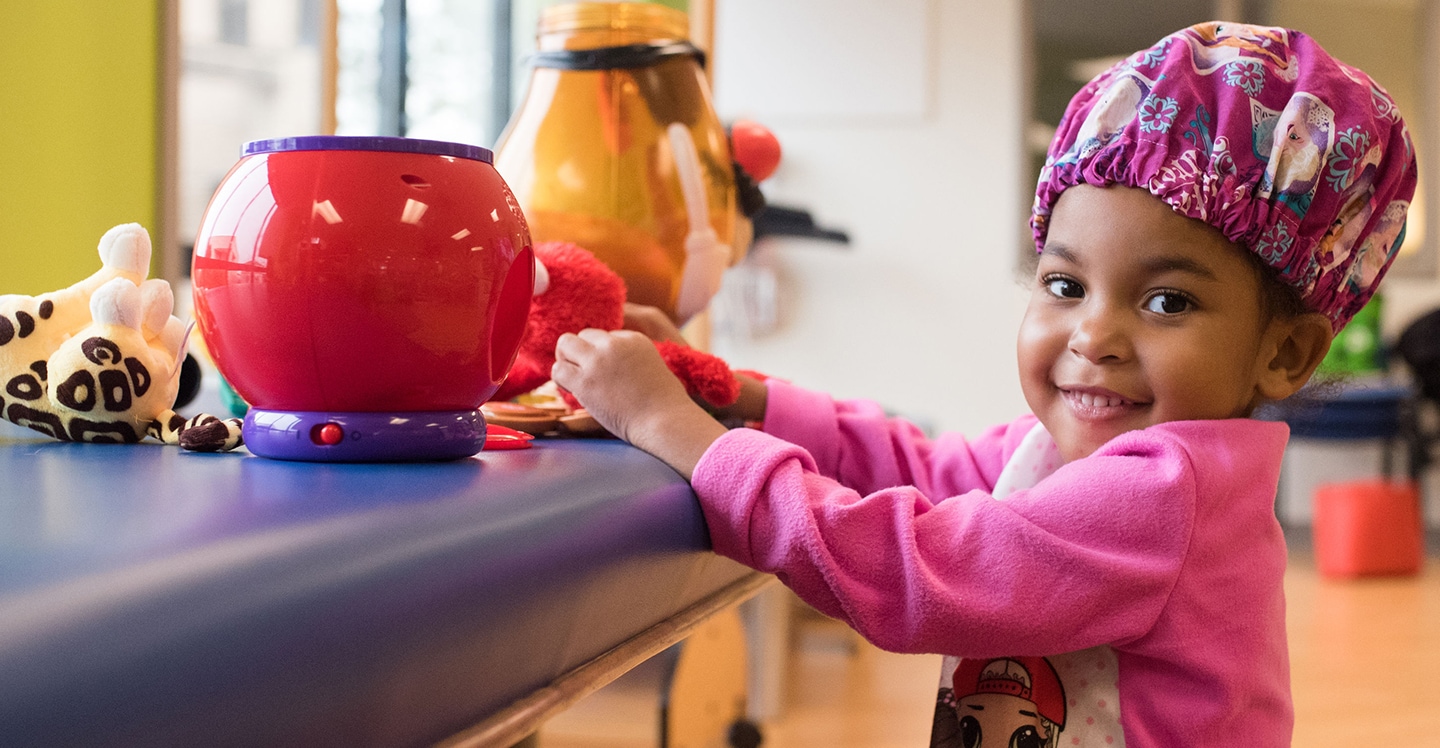 Patient girl plays with toys at rehab appointment