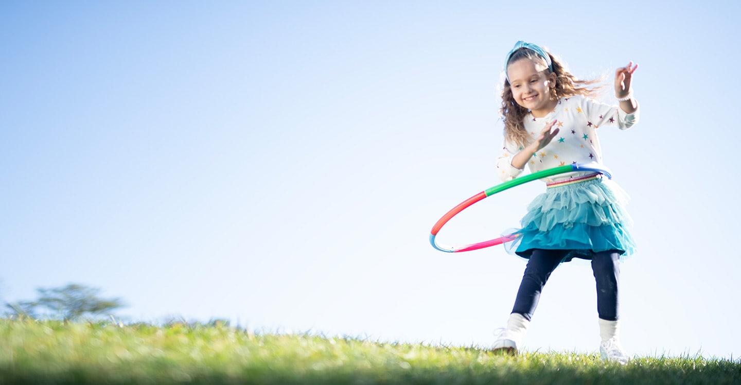 Happy patient hoola hoops outside.
