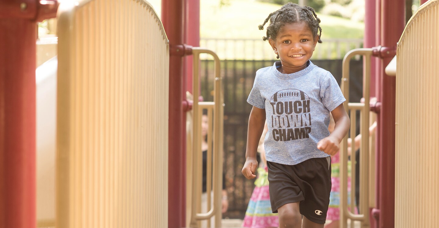 Child running and playground at preschool