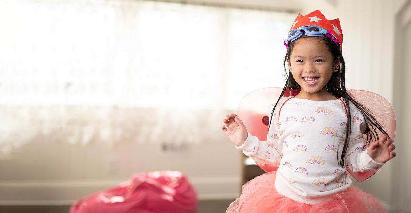 Happy young girl plays dress up.