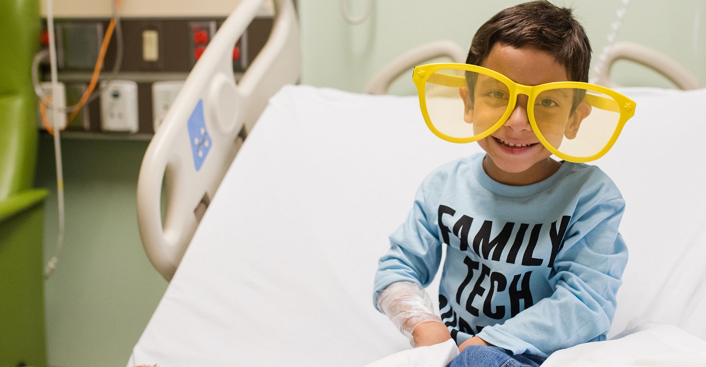 pediatric patient boy wearing silly glasses in hospital bed