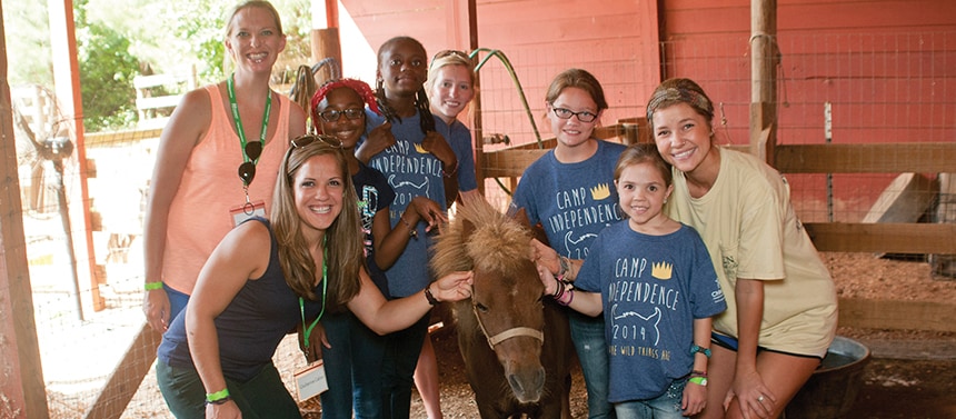 Girls with counselors at summer camp horse stables