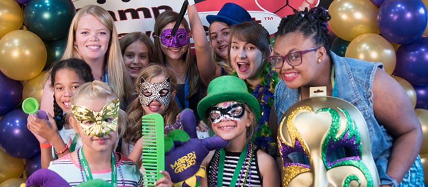Girls with counselors at summer camp Mardi Gras celebration