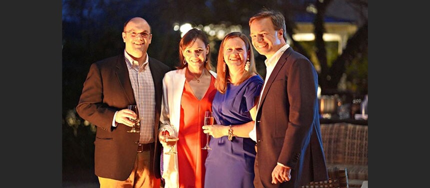 Four people standing outside together at night