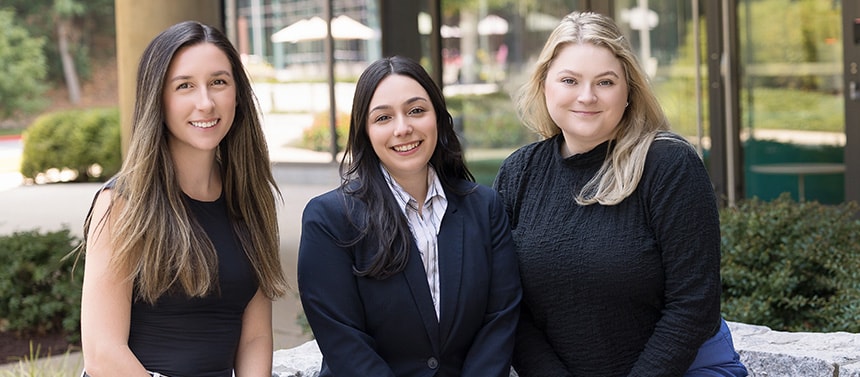 Three pharmacy resident students sitting and smiling