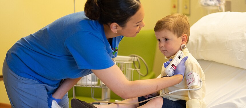 Nurse checks boy's temperature before surgery.