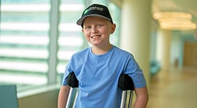Child on crutches in hallway