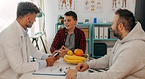 een boy, parent and registered dietician in medical exam room. 