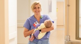A cardiac catheterization nurse holds an infant in the Children’s Heart Center