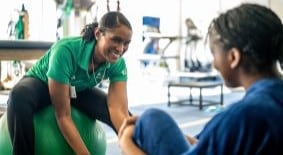 physical therapist looking at young athlete's leg