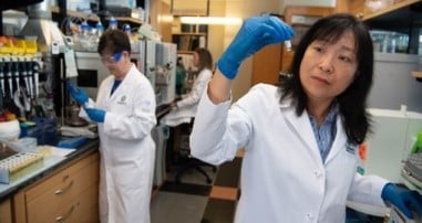 Researcher holding vile in lab