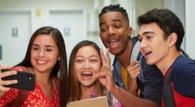 Group of teenagers taking a selfie in the school hallway
