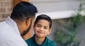 Dad talking to elementary age son on steps