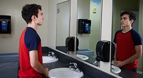 Teen boy looking at mirror