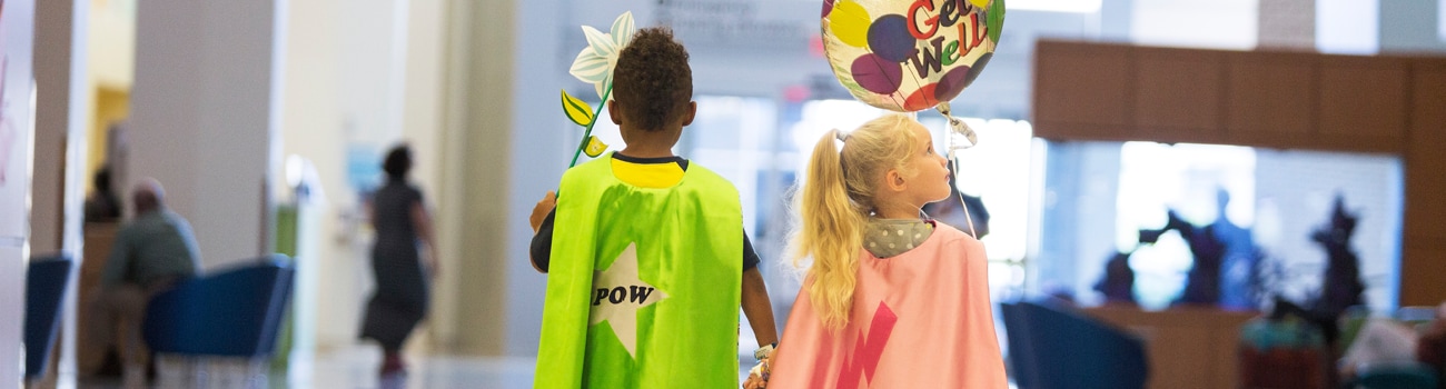 Boy and girl walking together in capes