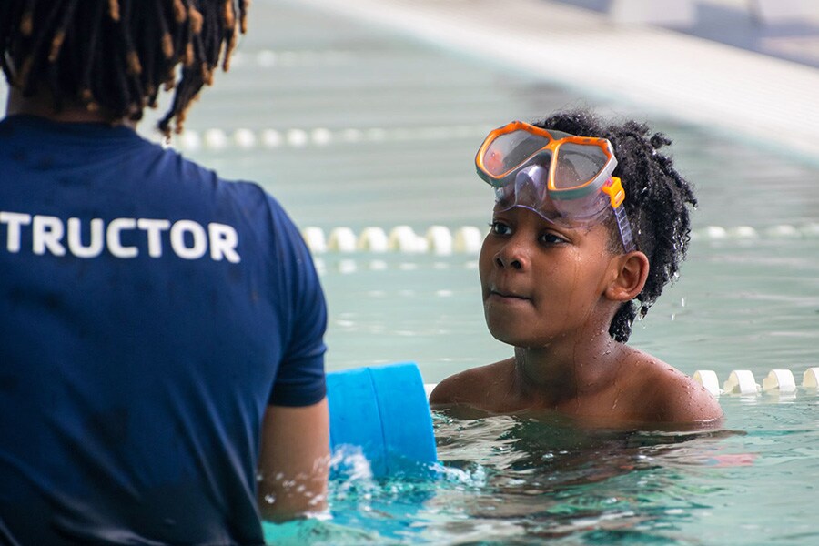 School age boy takes swim lessons at a metro Atlanta YMCA to practice water safety and drowning prevention. 