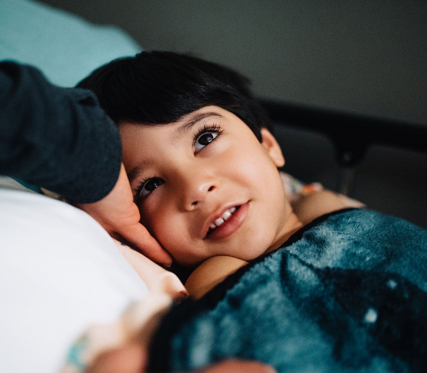 boy smiling in pediatric hospital bed