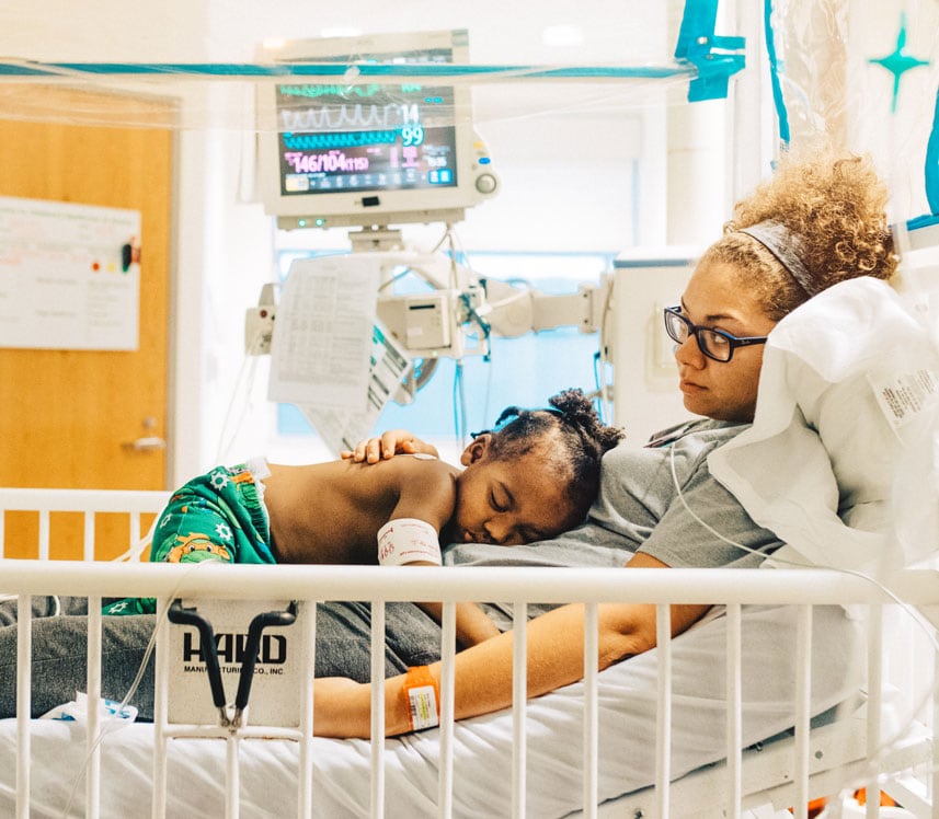mother holding son in pediatric hospital bed