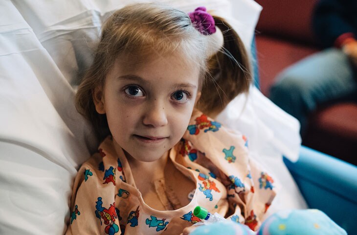 girl proudly shows her scars from cardiac surgery at pediatric hospital