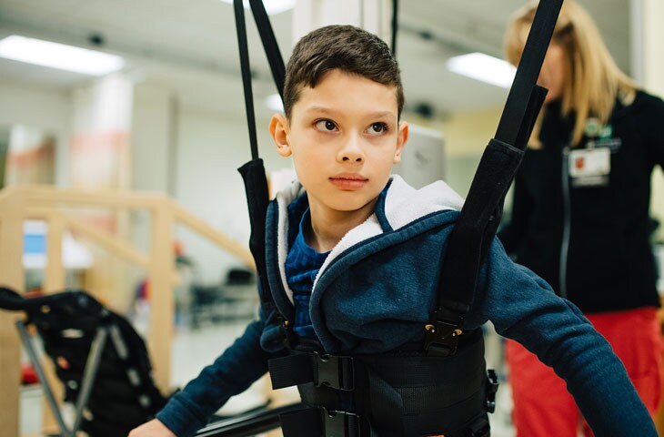 boy using robotic technology for pediatric orthopedic therapy