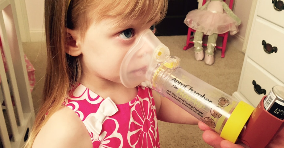 Young asthma patient uses an inhaler.