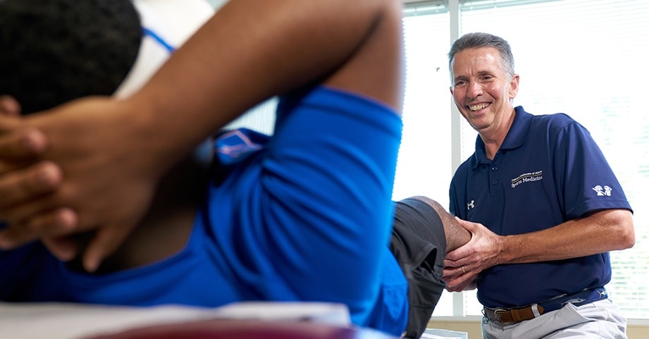 Dr. Busch in clinic with a knee injury patient.