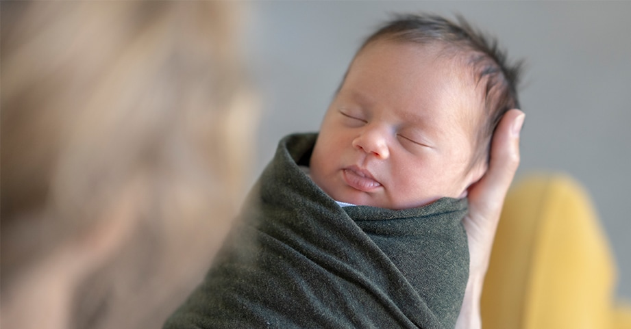 Baby being swaddled in a blanket