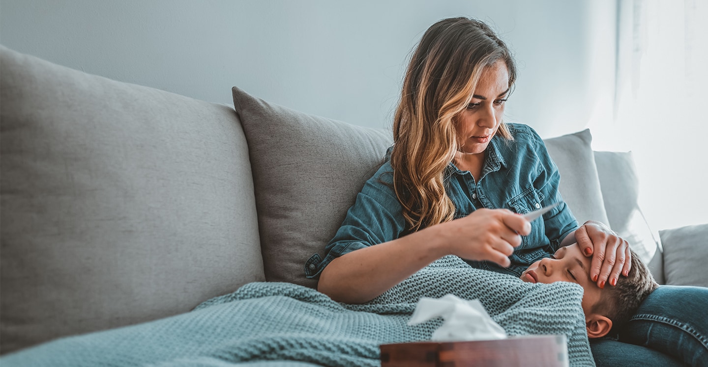 Mom reading thermometer to check son's fever