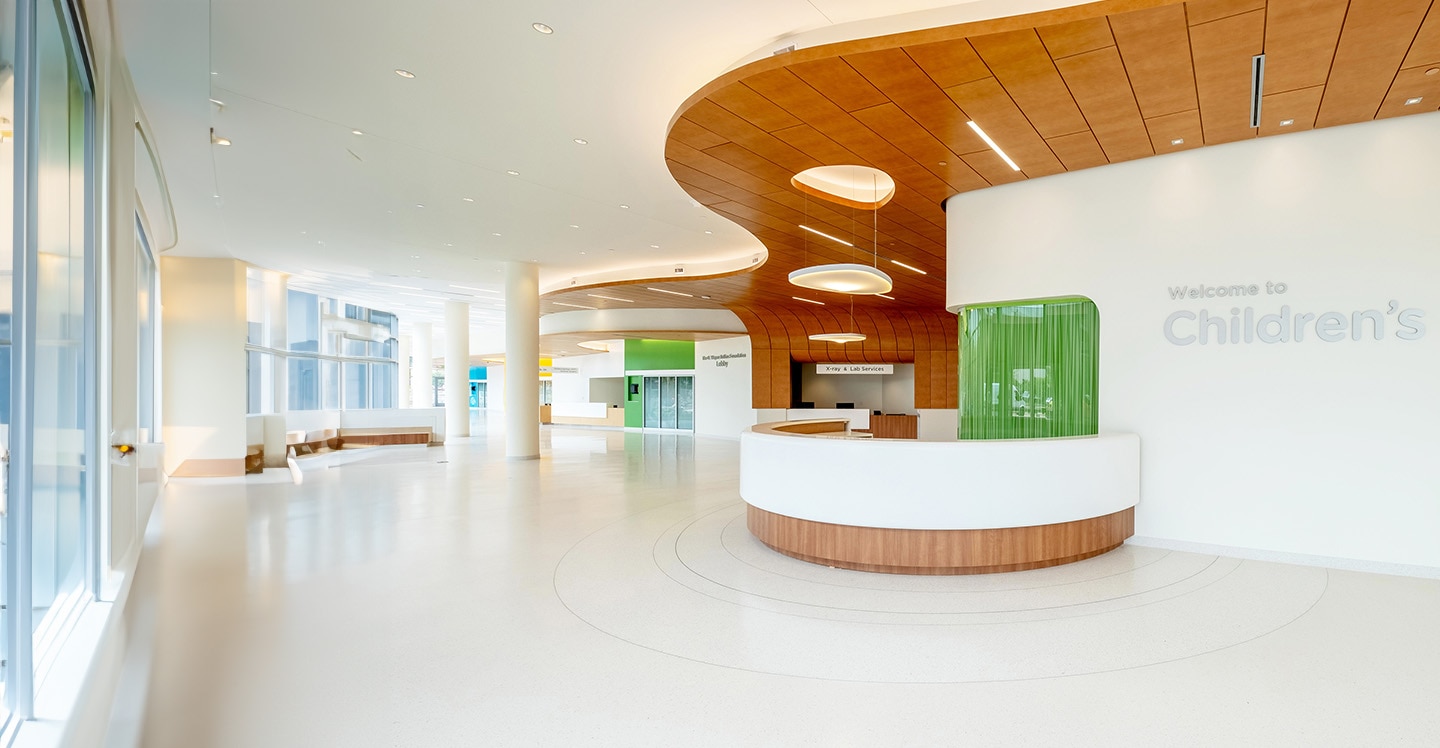 Check-in desk in the lobby of a pediatric hospital with a sign that reads “Welcome to Children’s”